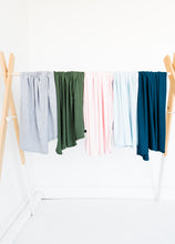 Load image into Gallery viewer, our collection of bamboo stretch swaddle blankets drapped side by side