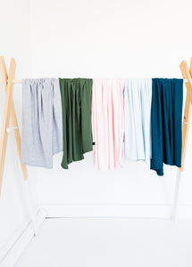 our collection of bamboo stretch swaddle blankets drapped side by side