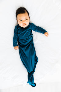 baby wearing our knotted baby gown in midnight teal