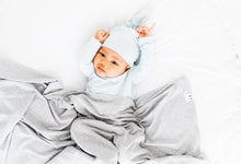 Load image into Gallery viewer, a baby boy wearing our baby blue stripe knotted gown and top knot hat while covered in our swaddle blanket in heathered grey