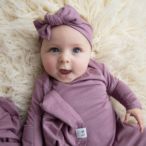 Baby wearing our mauve purple knotted gown, swaddle and headband
