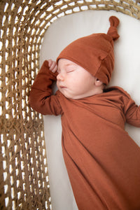 Knotted Baby Gown and Top Knot Hat in the colour Rust