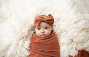 Baby wearing our top knot headband in Rust 