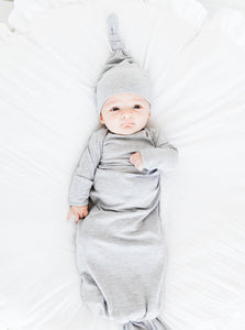 a baby boy wearing our heathered grey top knot hat and heathered grey knotted gown